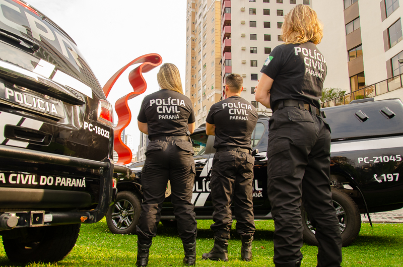 Três policiais civis entre viaturas