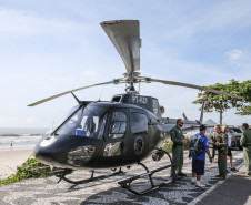 Helicóptero da PCPR e pessoas interagindo com policiais