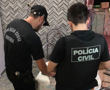 Policiais civis recolhendo notebook em residência