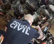 Policial civil observa motores de veículos desmontados
