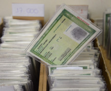 Centenas de documentos em caixas, com um RG em destaque