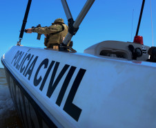 No interior de um barco da polícia civil, policial aponta arma