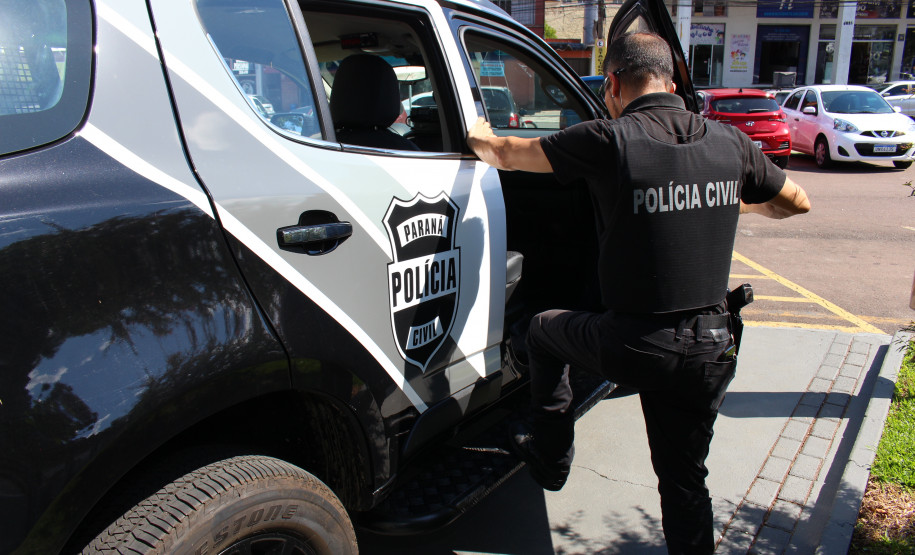 Policial civil entrando em viatura