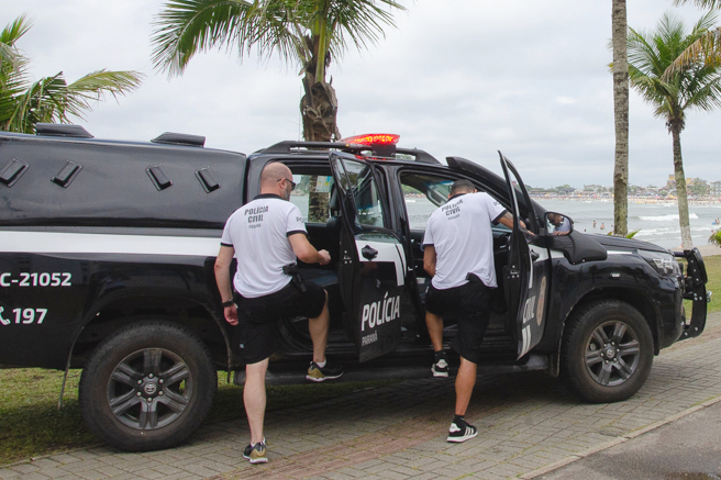 Dois policiais civis entrando em viatura