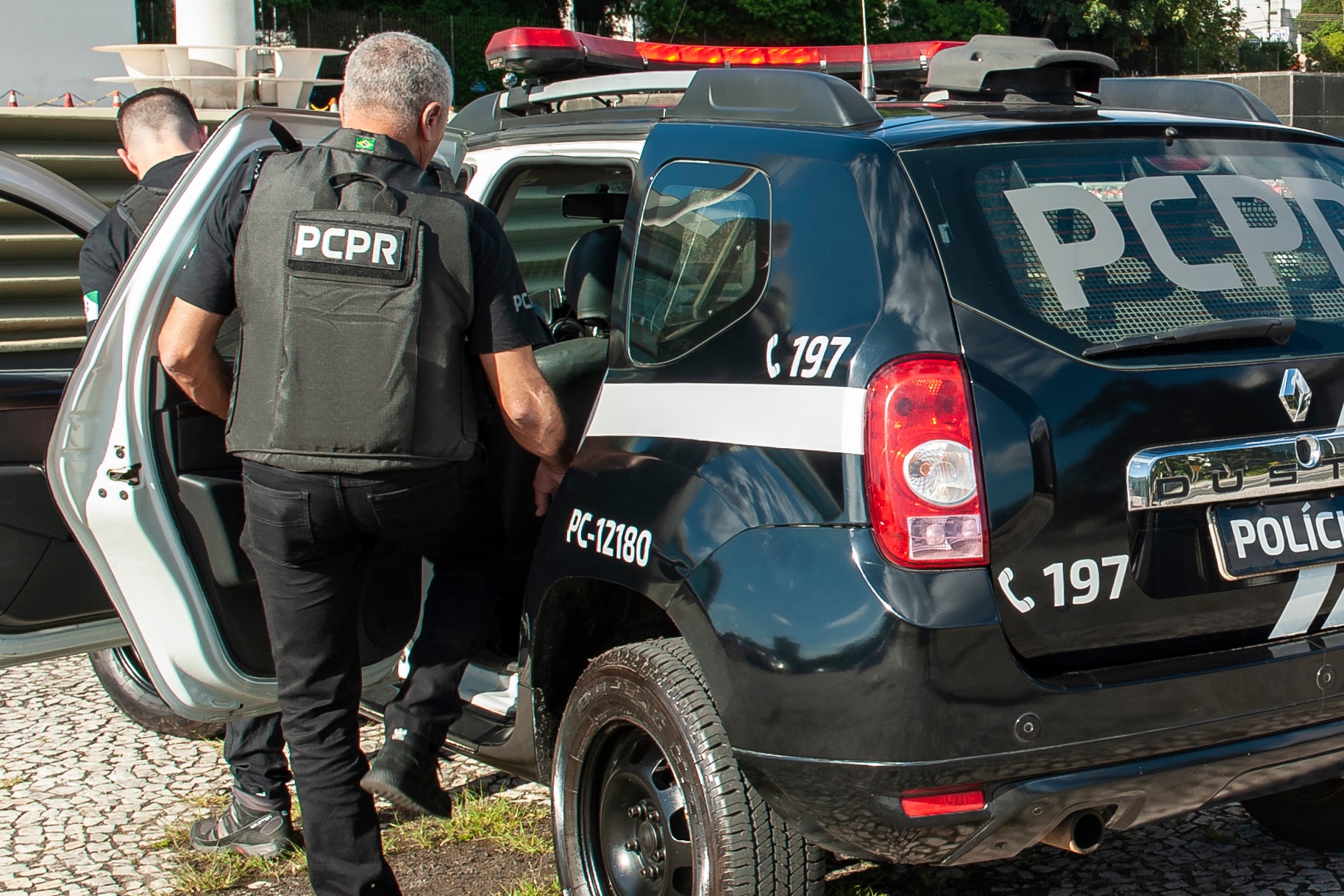 Policiais civis entrando em viatura