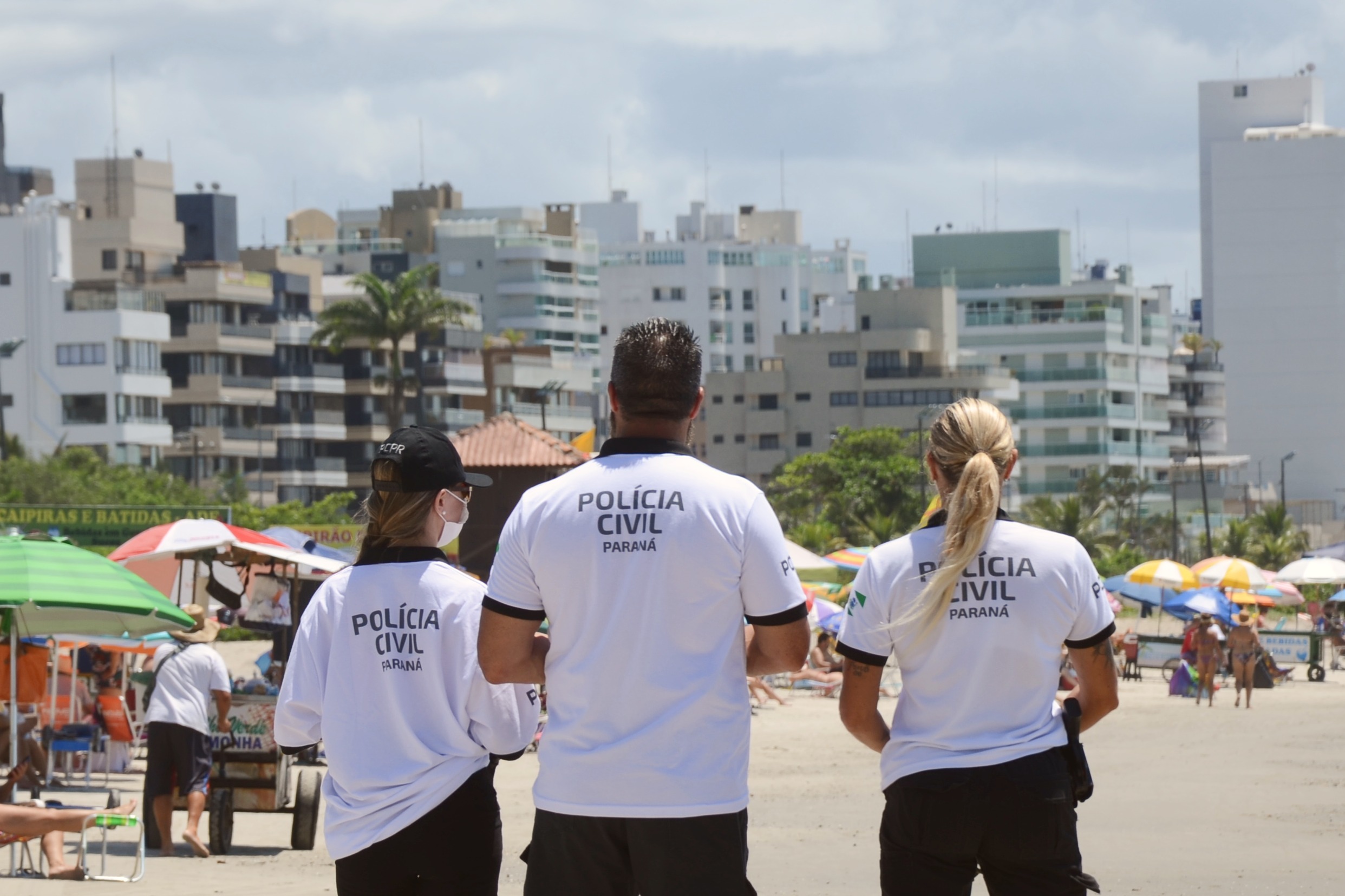 Três policiais civis observam o movimento no litoral