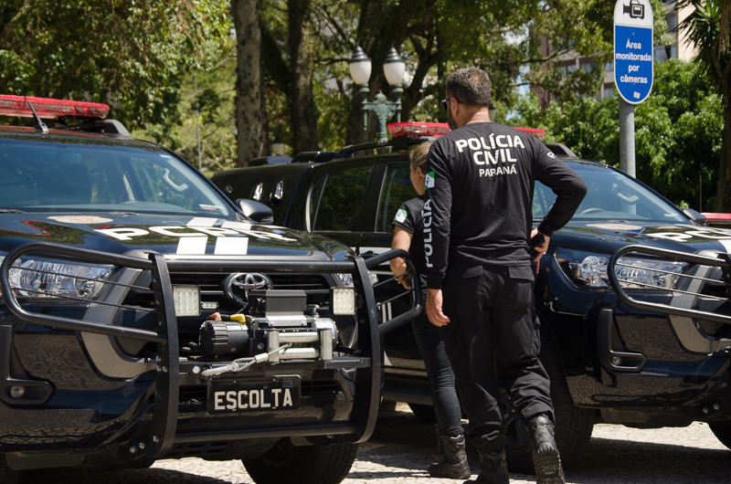 Dois policiais civis entre viaturas
