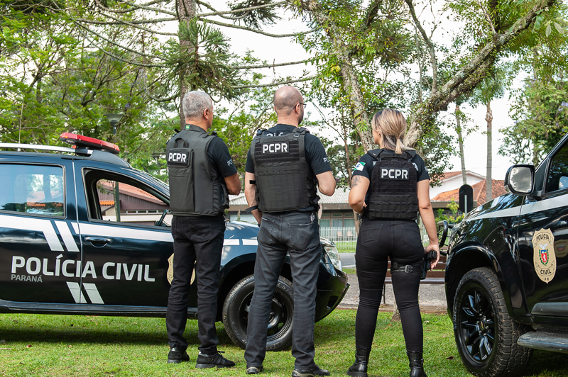 Três policiais civis entre viaturas