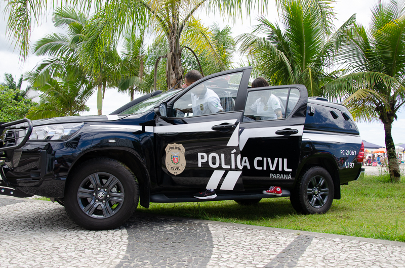 Dois policiais civis entrando em viatura