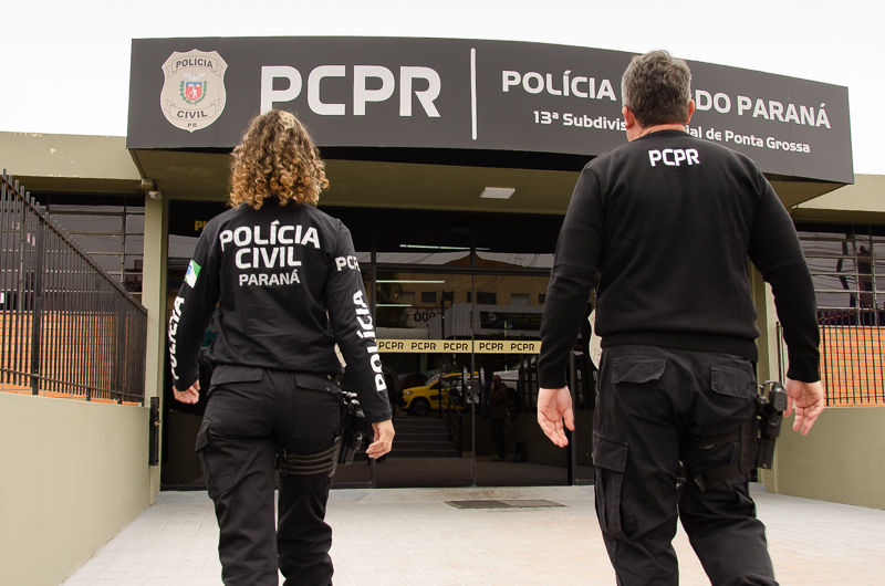 Dois policiais civis entrando em delegacia