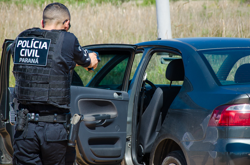 Policial civil apontando arma em abordagem a veiculo