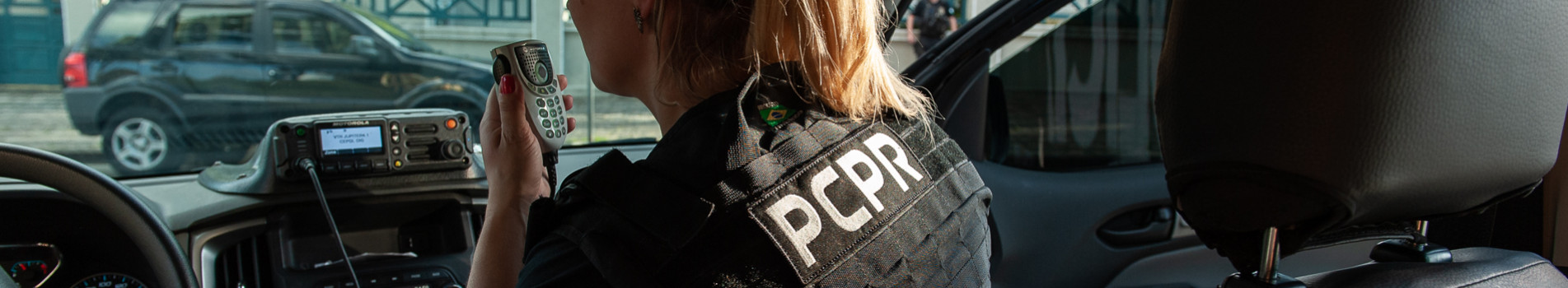 policial feminina na viatura fala ao rádio