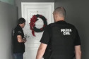 Dois policiais civiscumprindo mandado de prisão.
