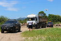 Policial civil observa caminhão entre duas viaturas