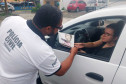 Policial civil entregando panfleto sobre dengue para motorista