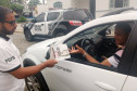 Policial civil entregando panfleto sobre dengue para motorista