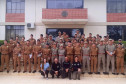 Dezenas de policiais militares e bombeiros reunidos com palestrantes da polícia civil para foto oficial