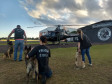 Policiais civis e cães policiais em treinamento com aeronave 