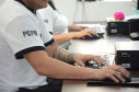 Dois policiais civis sentados, ao computador