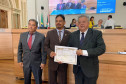 Homenageado recebendo diploma em foto posada