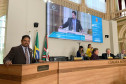 Homenageado discursando co m telão em segundo plano