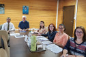 Participantes reunidos à mesa, para discutir o cronograma