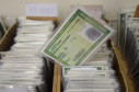 Centenas de documentos em caixas, com um RG em destaque