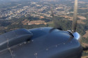 Detalhe da hélice de aeronave. Ao fundo, espaço urbano