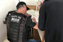 Policiais civis à mesa preenchendo documentos