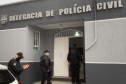 Três policiais civis entrando na delegacia