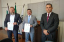 Delegado-geral e superintendente da CGU apresentando documento assinado. Junto, chefe da divisão de combate à corrupção.