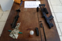 Armas desmontadas e material de limpeza sobre uma mesa