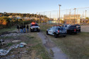 Vários policiais civis ao  lado de três viaturas.
