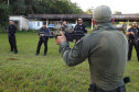 Policial civil apontando fuzil enquanto fala com alunos