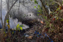 Área com árvores e lixo pegando fogo