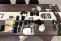 Diversos materiais apreendidos, sobre uma mesa