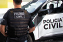 Policial civil ao lado de viatura