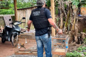 Policial civil segurando duas gaiolas com passaros