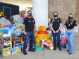 Policiais civis posando para foto junto a brinquedos doados