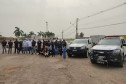 Policiais civis envolvidos no evento posando para foto ao lado de duas viaturas