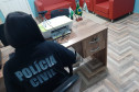 Policial de costas, no espaço exclusivo da delegacia