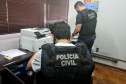 Dois policiais civis analisando documentos