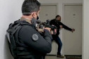 Dois policiais civis empunhando armas em momento da operação