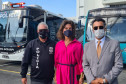 Envolvidos no projeto posando para foto em frente aos ônibus da PCPR e TJ