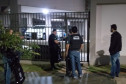 Policiais civis na calçada, em frente a local a ser investigado