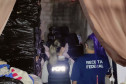 Policial civil e servidora da Receita Federal observam depósito com cigarros contrabandeados