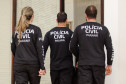 Três policiais civis de costas