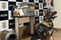 Cão policial ao lado de droga apreendida
