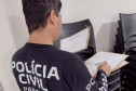 Policial civil com documentos em mãos