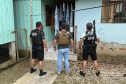 Três policiais em frente a residencia